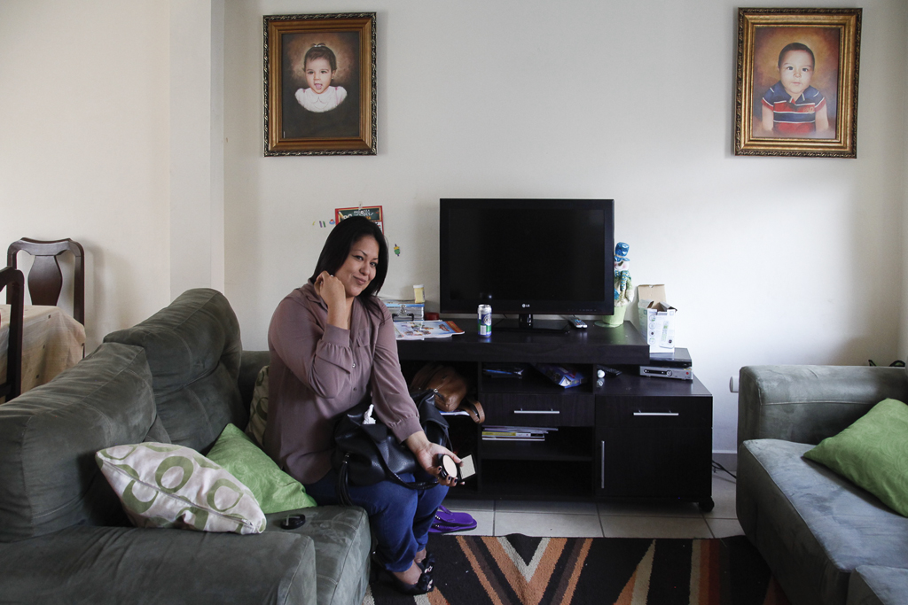A woman retouchs her make up in a medium- high class neighborhood´s house. San Salvador. El Salvador.